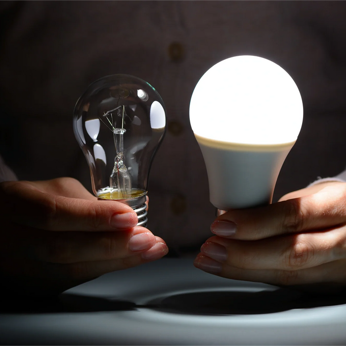 Persona che sostituisce una lampadina tradizionale con una lampadina LED a risparmio energetico