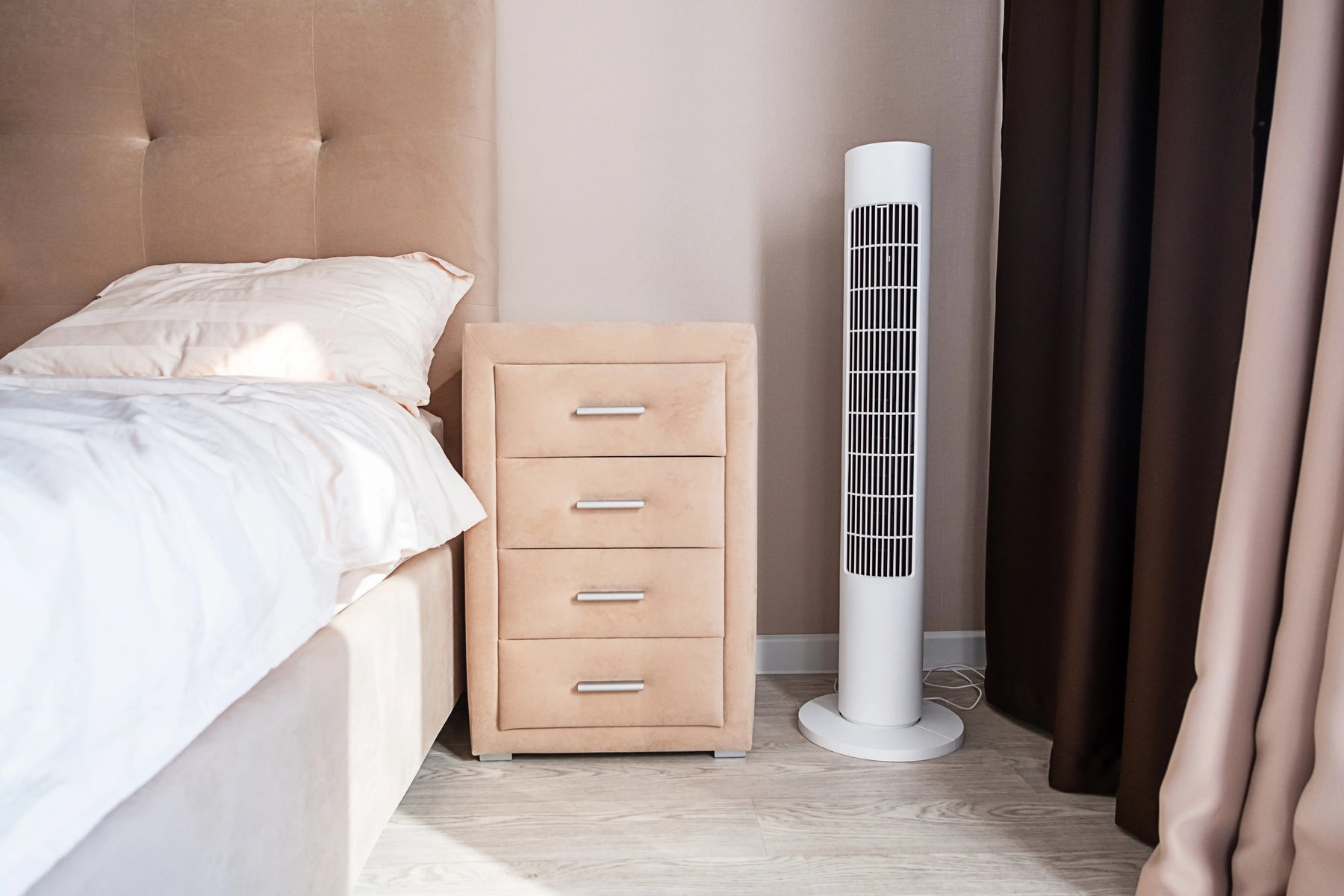 Ventilatore a colonnina bianco posizionato in un soggiorno moderno
