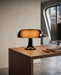 Lampada da Tavolo Artemide Nessino Nera accesa su scrivania di design