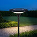 Lampione solare da giardino Elcart E-Flower, acceso su palo lungo un vialetto in giardino