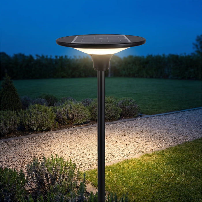 Lampione solare da giardino Elcart E-Flower, acceso su un vialetto di ghiaia